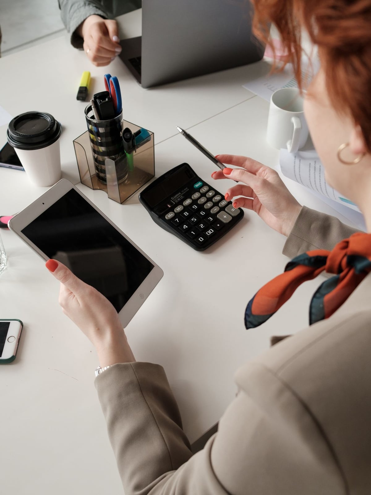 Planning a studio session using a tablet and calculator on a desk